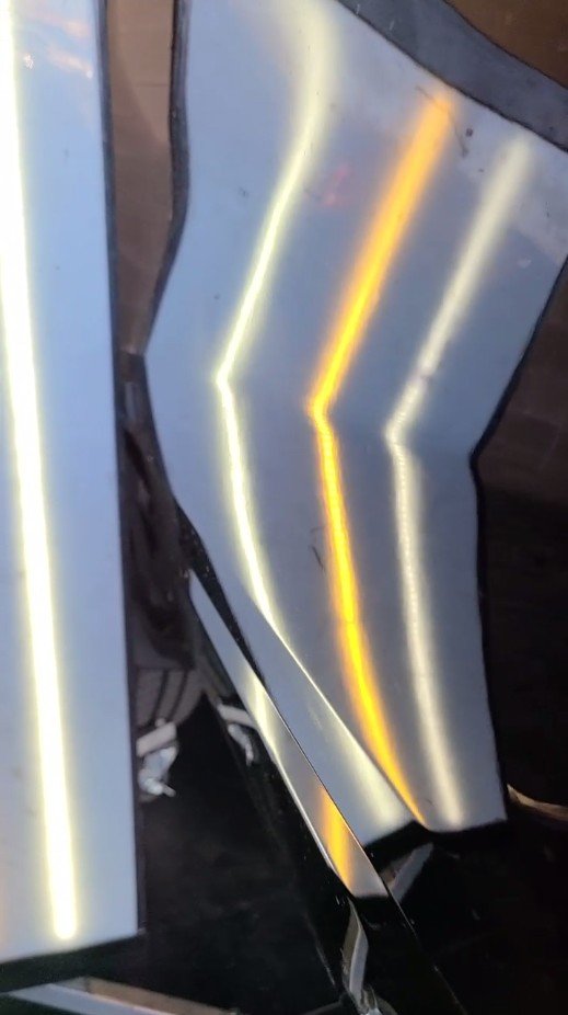 The same panel after paintless dent repair — reflection lines straight